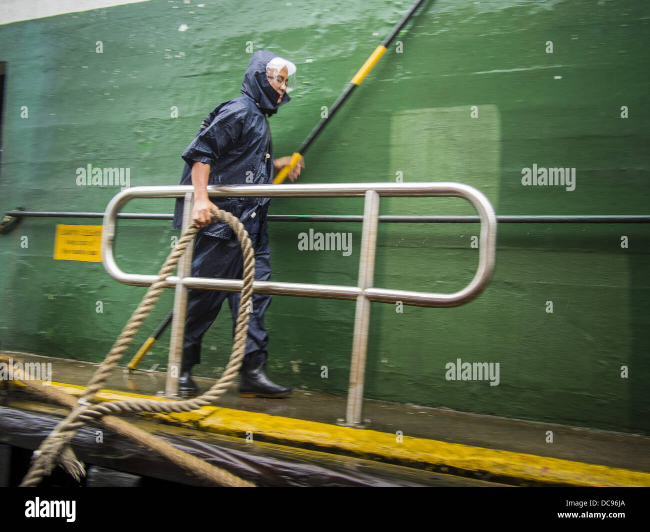Hong Kong. 13th August 2013.  A Star Ferry worker pulls a rope from a Star Ferry ship to shore during Typhoon Utor in Hong Kong. Typhoon Utor (known in the Philippines as Typhoon Labuyo) is an active tropical cyclone located over the South China Sea. The eleventh named storm and second typhoon of the 2013 typhoon season, Utor formed from a tropical depression on August 8. The depression was upgraded to Tropical Storm Utor the following day, and to typhoon intensity just a few hours afterwards. Credit:  ZUMA Press, Inc./Alamy Live News Stock Photo