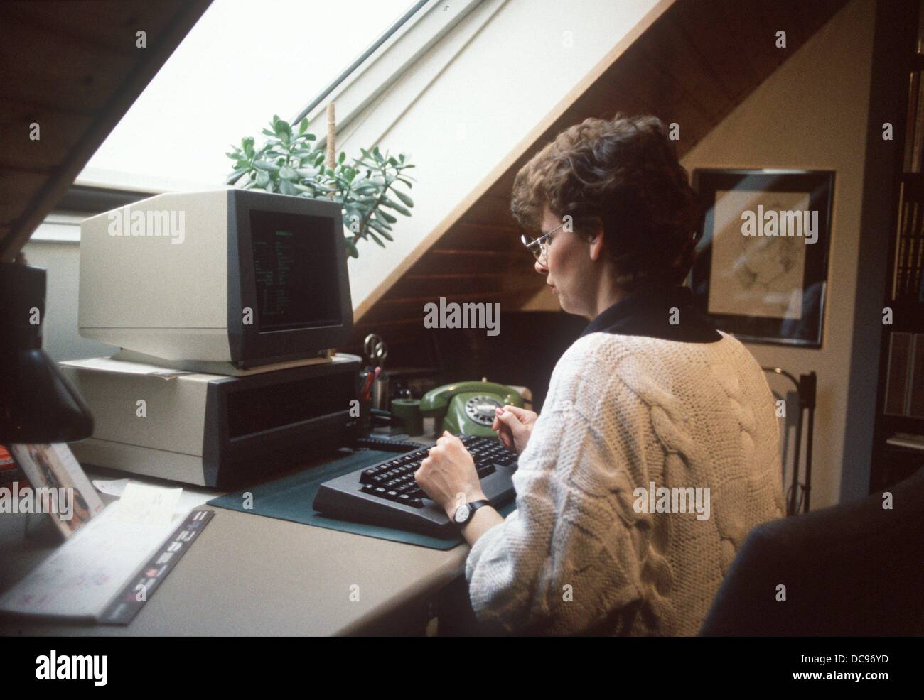 A young woman in front of her computer in home office, photographed in 1986. Stock Photo