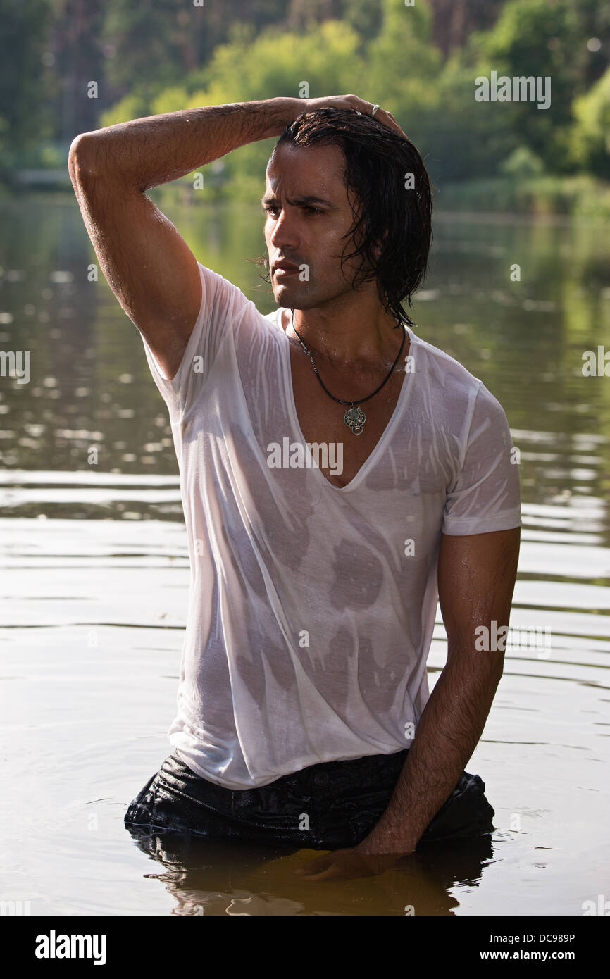 handsome young man in wet clothes stands in water Stock Photo Alamy