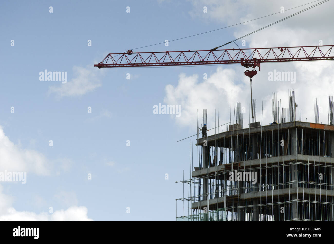 Workers on a high rise construction project of residential and commercial property use a crane to lift material in Ulan Bator, Mongolia. © Olli Geibel Stock Photo