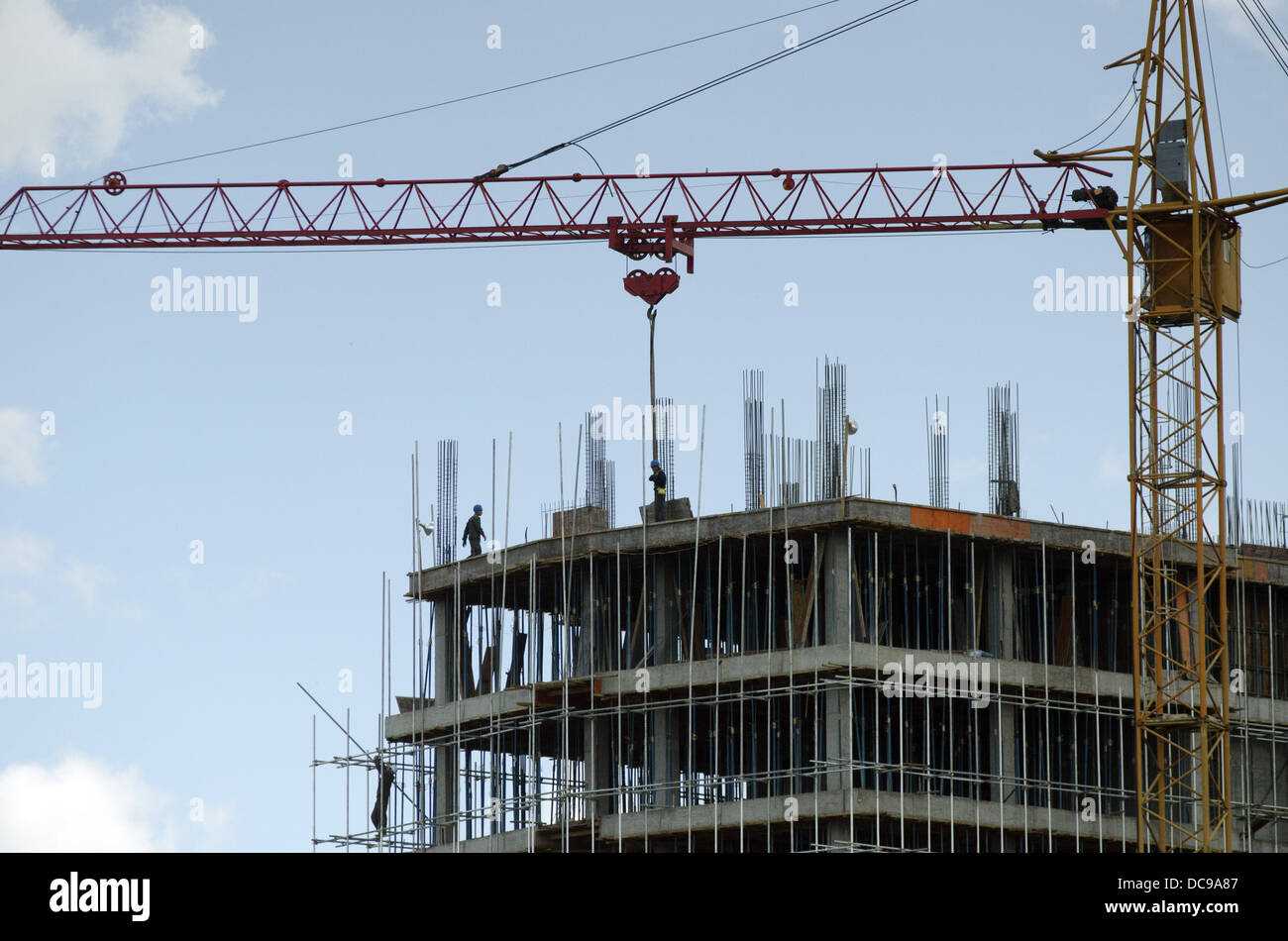 Workers on a high rise construction project of residential and commercial property use a crane to lift material in Ulan Bator, Mongolia. © Olli Geibel Stock Photo