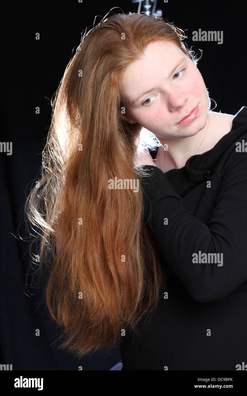 Portrait of a redhead female against a black background Stock Photo - Alamy