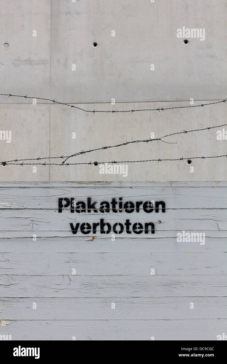 Sign 'Plakatieren verboten', German for 'no flyposting' with barbed wire Stock Photo
