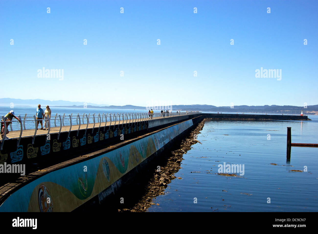 Walkers enjoying stroll Ogden Point Victoria BC protective breakwater walkway new safety railing Stock Photo