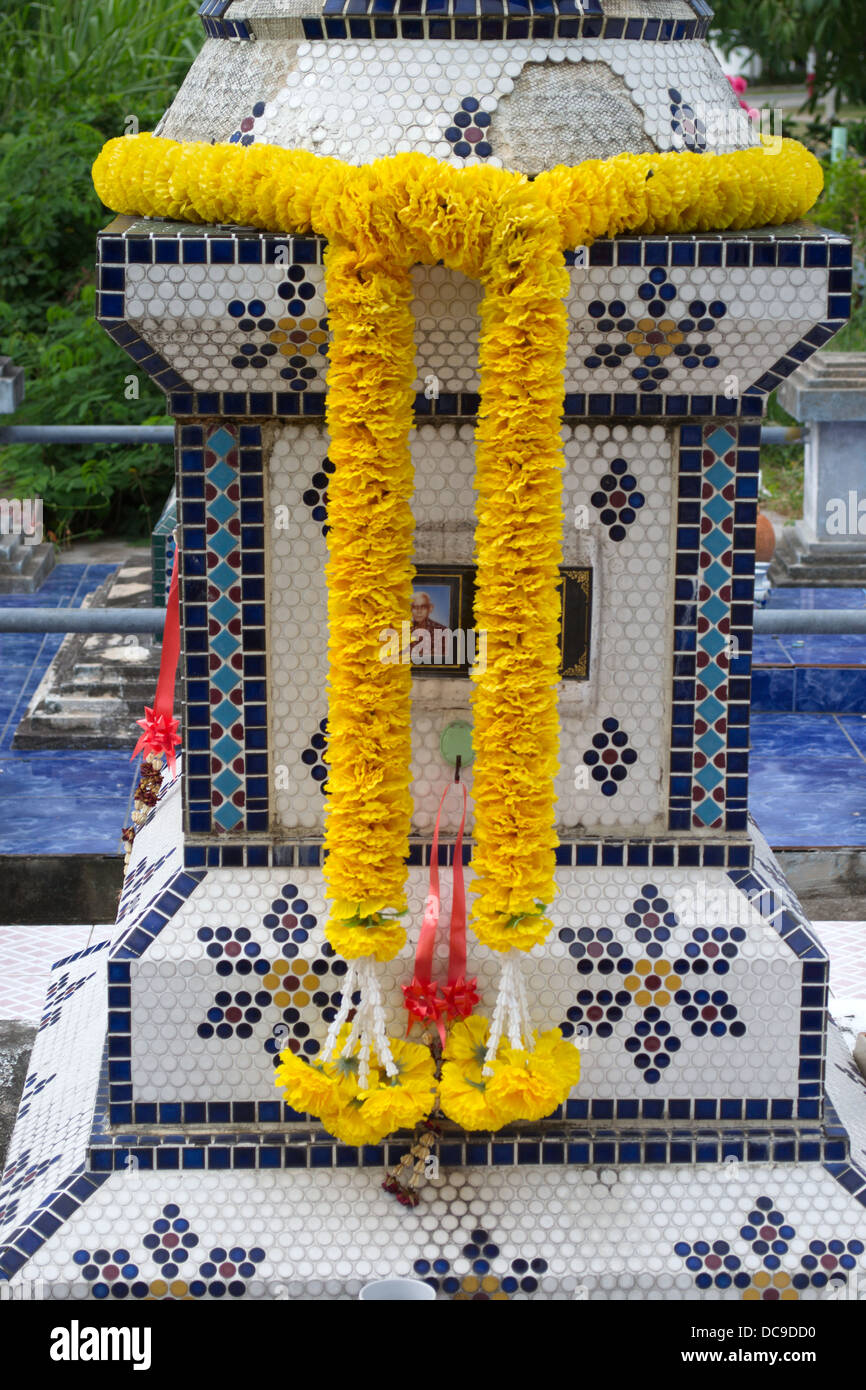 Tomb in Thailand draped with garlands to bring the dead person a good life in the afterworld. Stock Photo