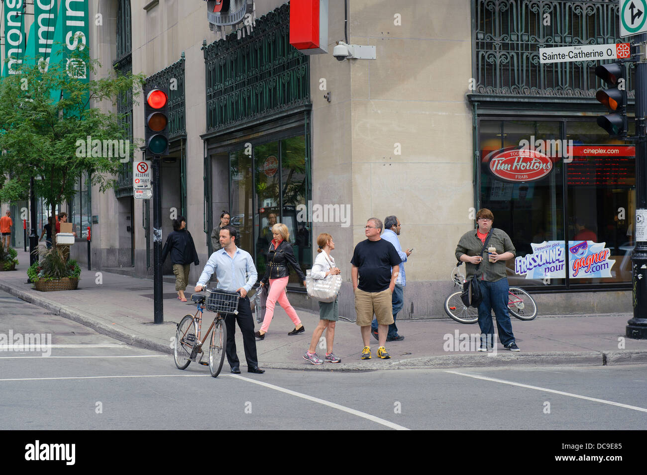 Man with bike waiting for the light to turn green before crossing a street in Montreal. Stock Photo