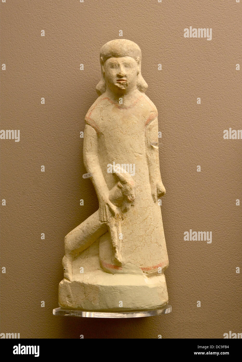 Limestone figurine made in Cyprus (statuette, about 100mm), depicting a devotee carrying the sacrificial animal. 7th or 6th cent Stock Photo