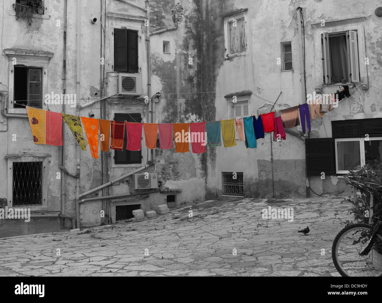Colourful washing hanging on a washing line on a black and white photograph of the back streets in Corfu Town in Greece Stock Photo