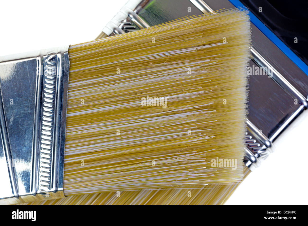 Close view of a sash paint brush atop a wider brush showing the bristles. Stock Photo