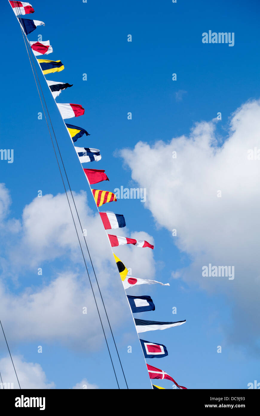 Lots of small marine international code flags on a yacht mast rope. Stock Photo