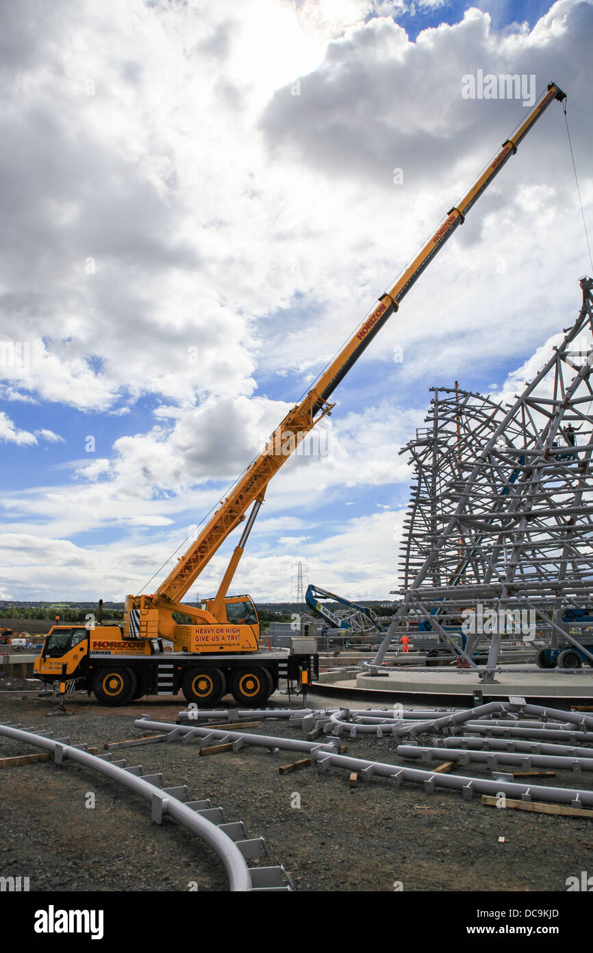 A mobile crane on a construction site hoisting steelwork on to a