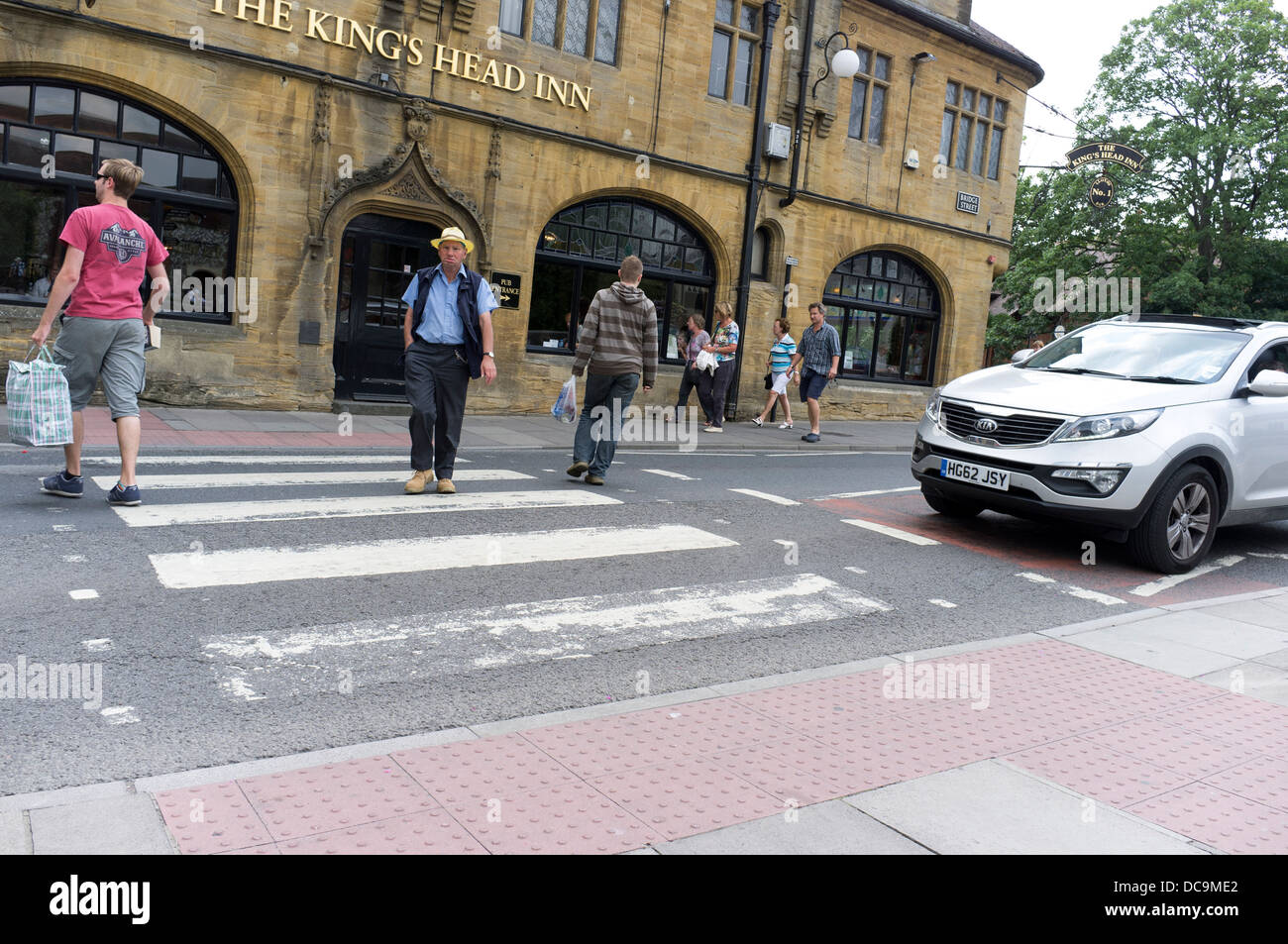 Car waiting while people cross road at pedestrian crossing UK Stock ...