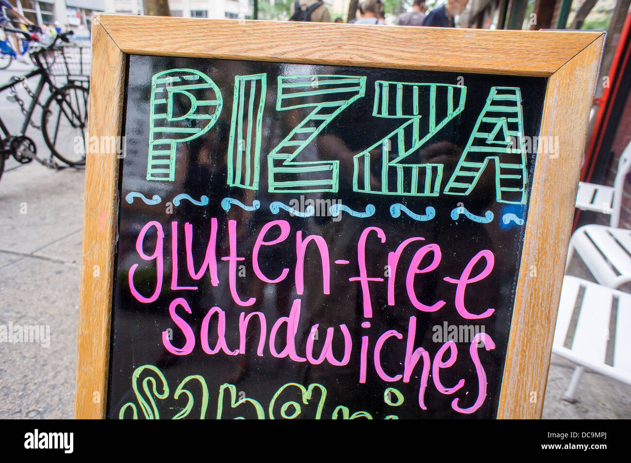 A sign outside of a restaurant in New York on Saturday, August 10, 2013 promotes their pizza and gluten-free sandwich offerings Stock Photo