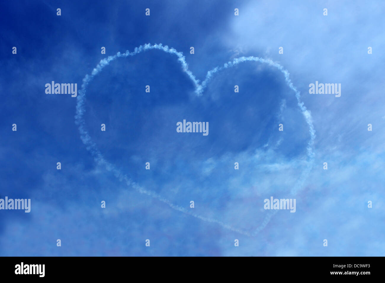 Vapor trail love heart in blue sky seen suring air display. Stock Photo