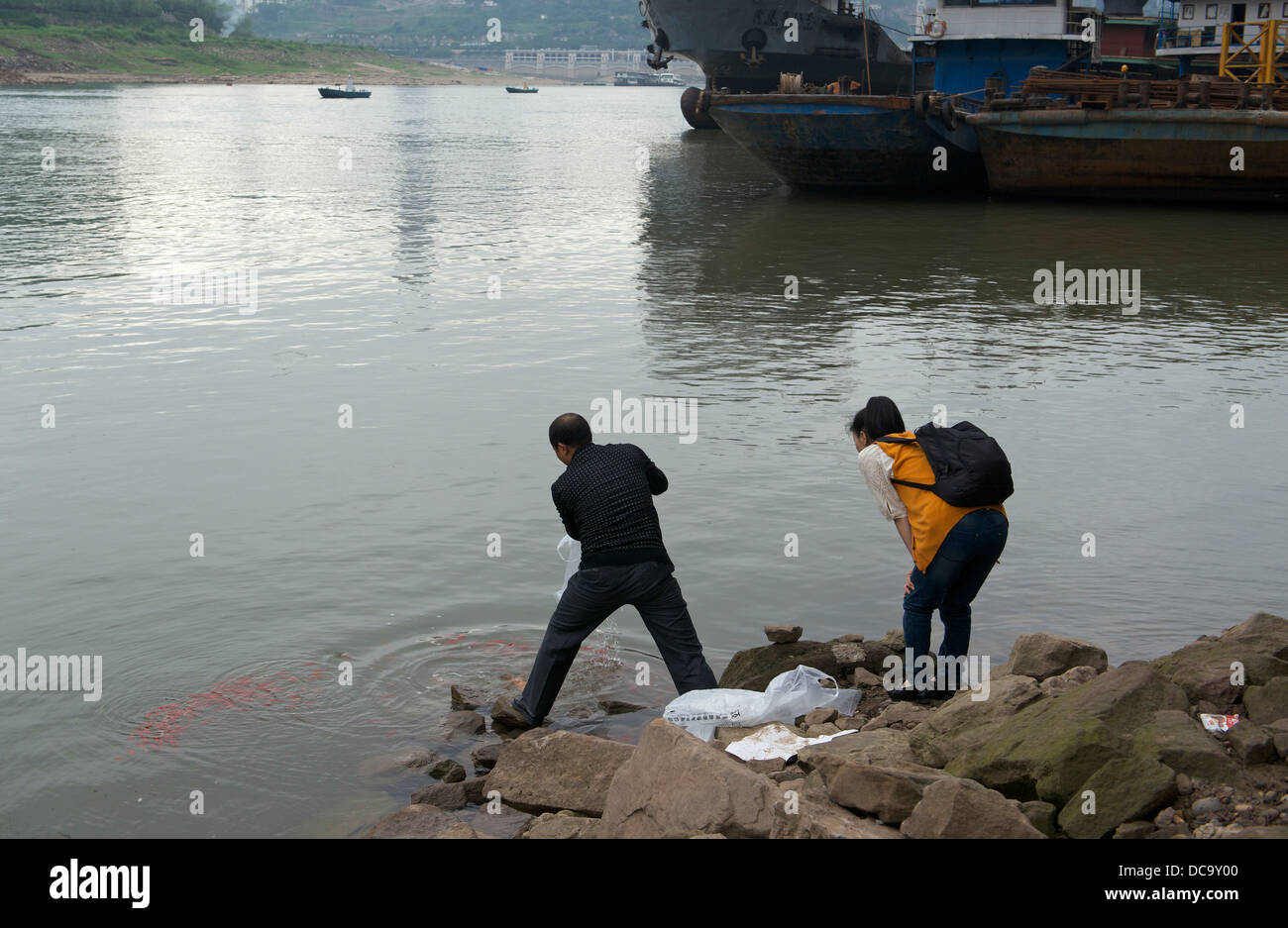 A couple release fishes in the Jialing River in Chongqing, China. 2013 Stock Photo