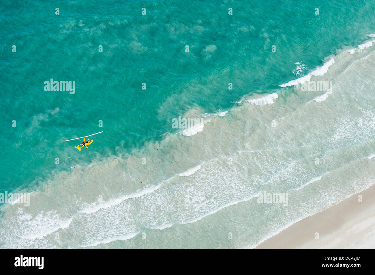 Small helicopter flying over the ocean Stock Photo