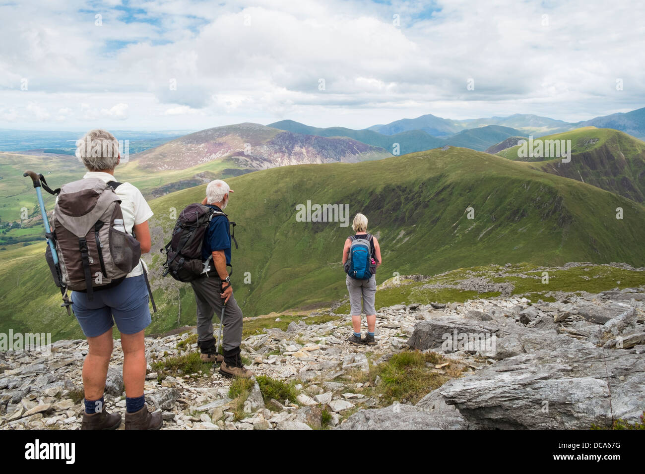 Three hikers looking at view northeast from Craig Cwm Silyn on Nantlle ridge walk in mountains of Snowdonia National Park in summer. North Wales, UK Stock Photo