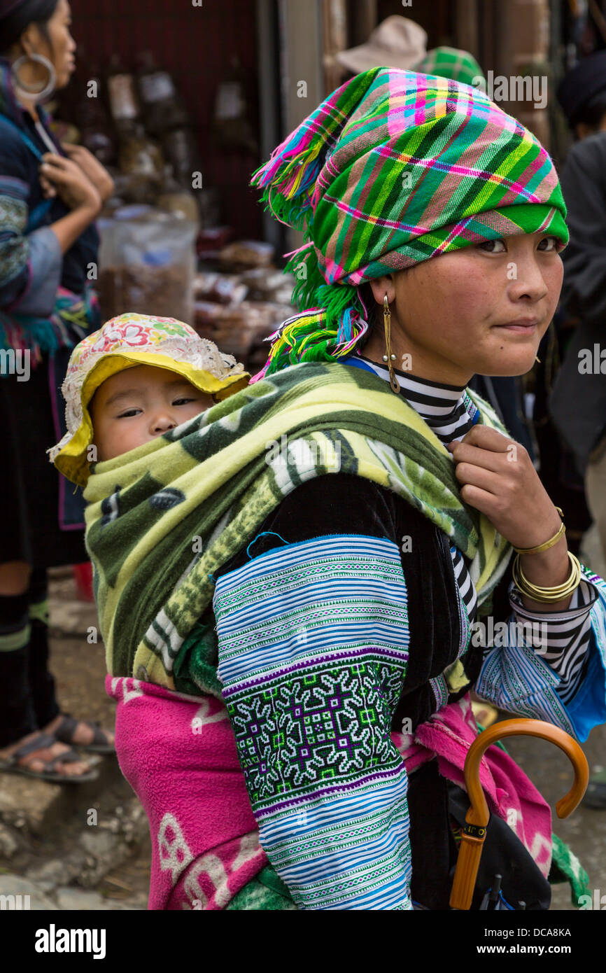 A young Hmong mother carrying her baby in Sapa, Vietnam, Asia. Stock Photo