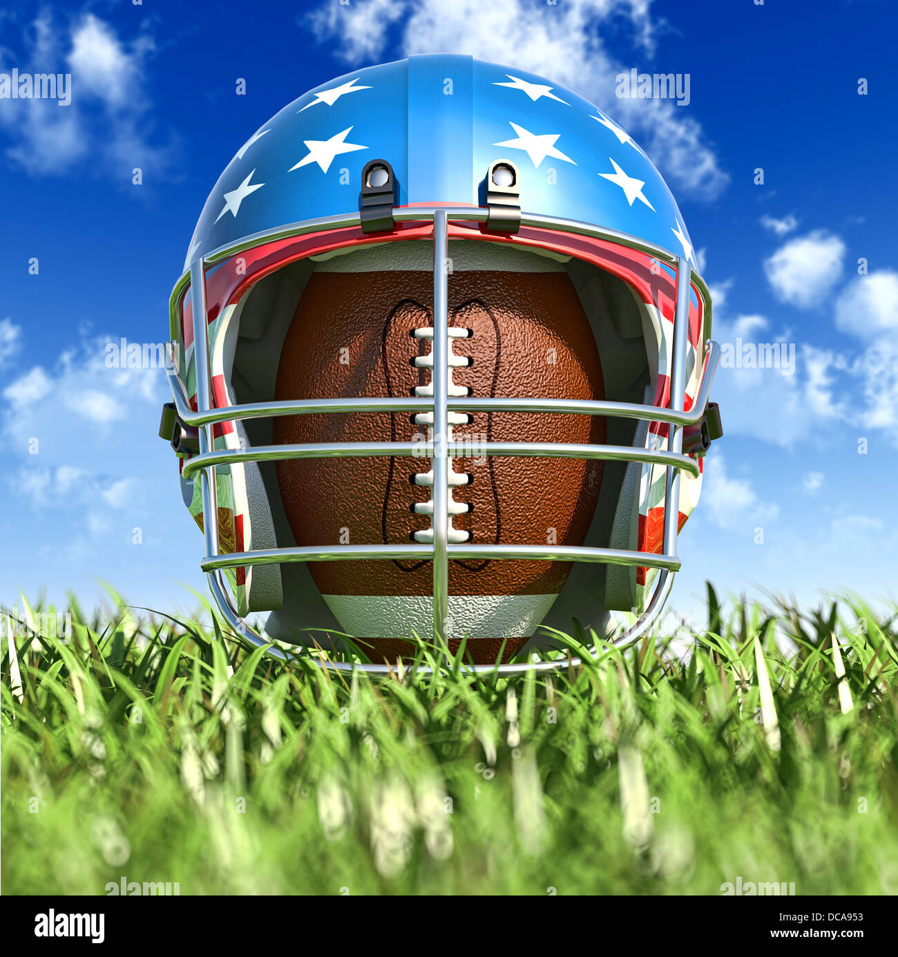 American football helmet over the oval ball, on the grass. Frontal Close up view, from the ground level. With sky. Stock Photo
