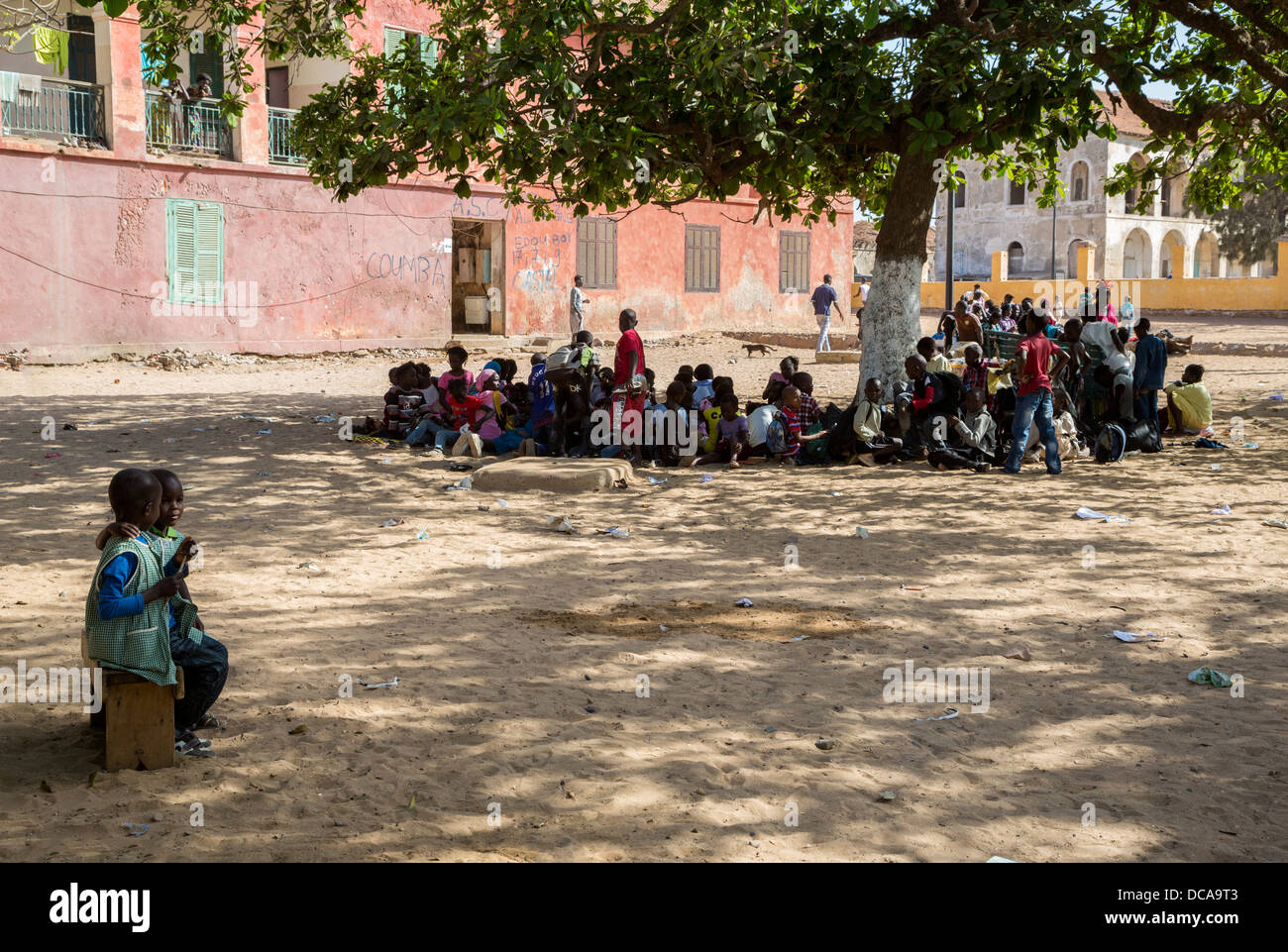 During Mid-day Sun People Seek Shade under Trees for their Conversations, Goree Island, Senegal. Stock Photo