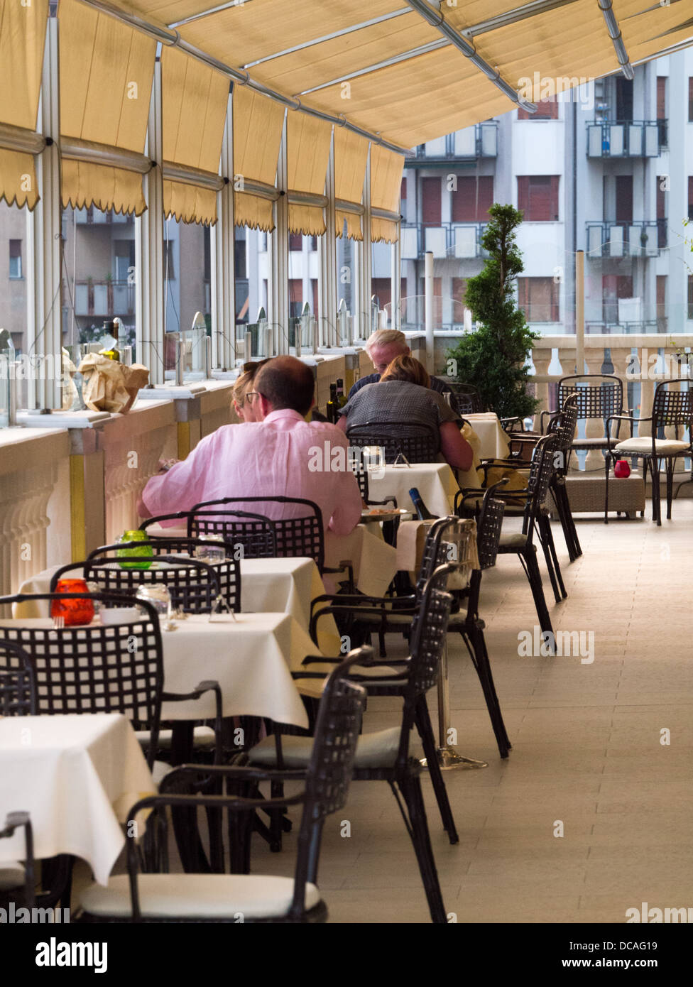 Diners eat al fresco on a roof terrace at a restaurant in Genoa, Italy Stock Photo