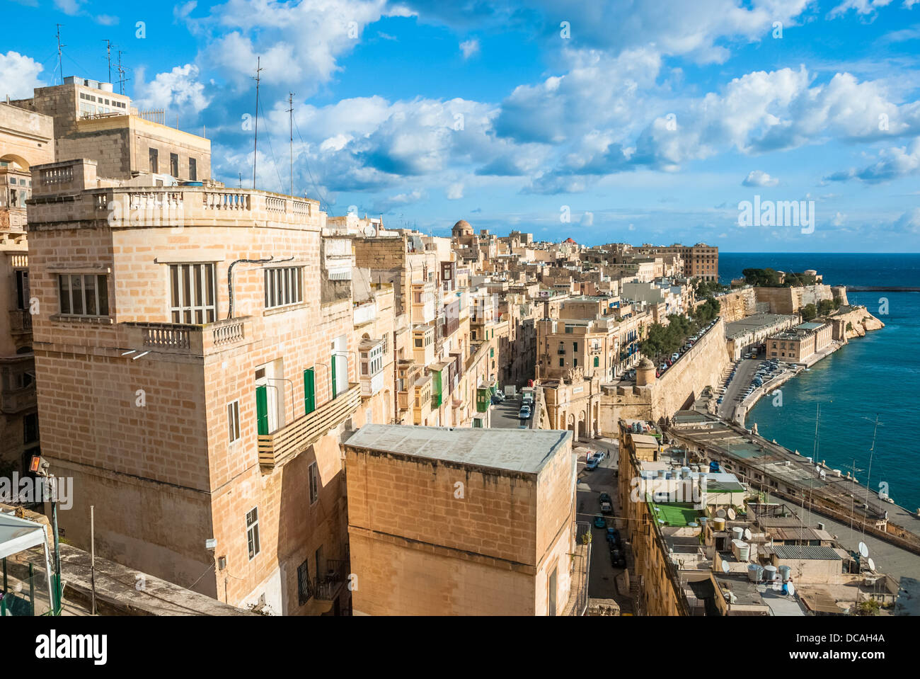 Sandstone buildings overlook the old harbor and Victoria Gate in the city of Valetta, Malta Stock Photo