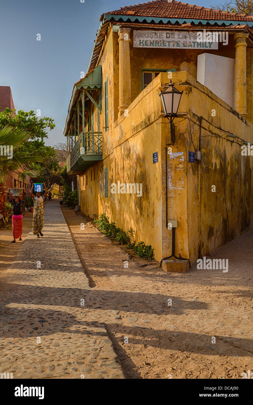 Musee des Femmes (Women's Museum) and Street Scene, Women Carrying Water, Goree Island, Senegal. Stock Photo