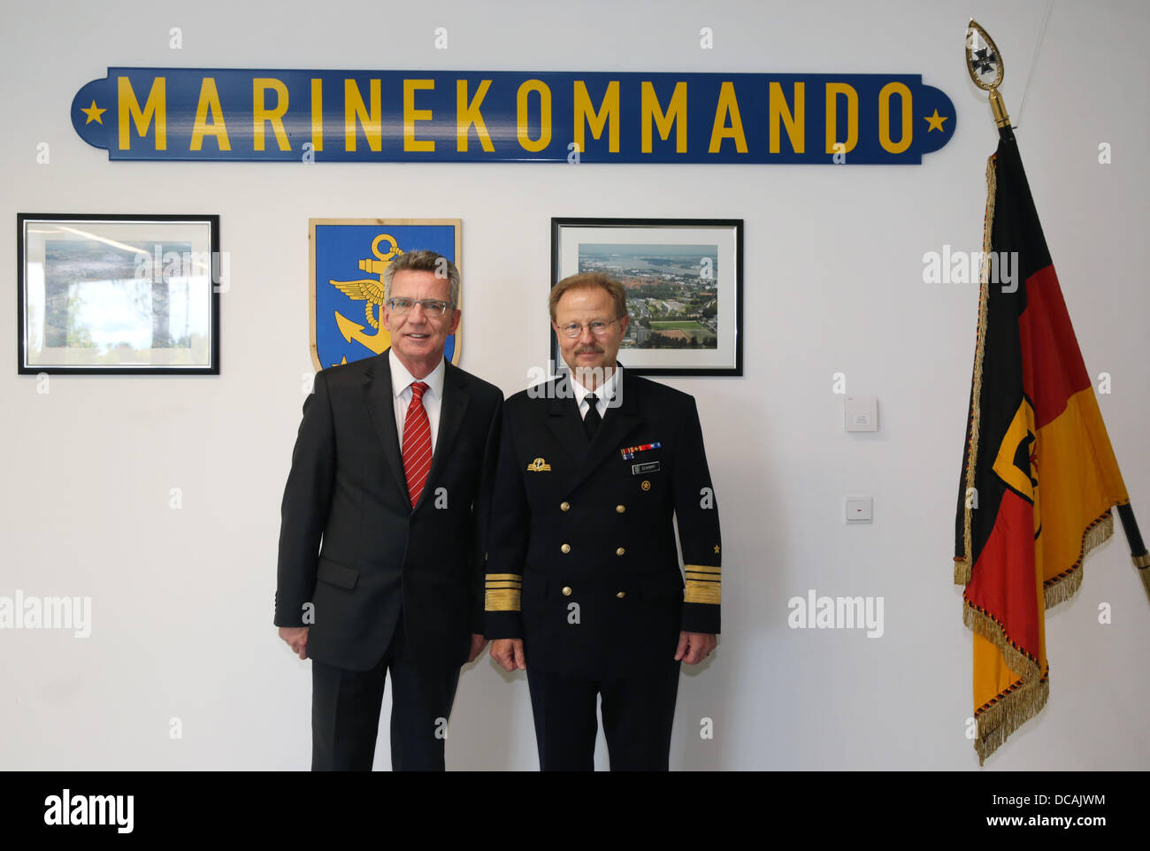 Rostock, Germany. 14th Aug, 2013. German Defence Minister Thomas de Maiziere (L) is greeted by command chief Vice Admiral Axel Schimpf (R) at the German Navy Command in Rostock, Germany, 14 August 2013. The minister is visiting the command as part of his summer tour. Photo: BERND WUESTNECK/dpa/Alamy Live News Stock Photo