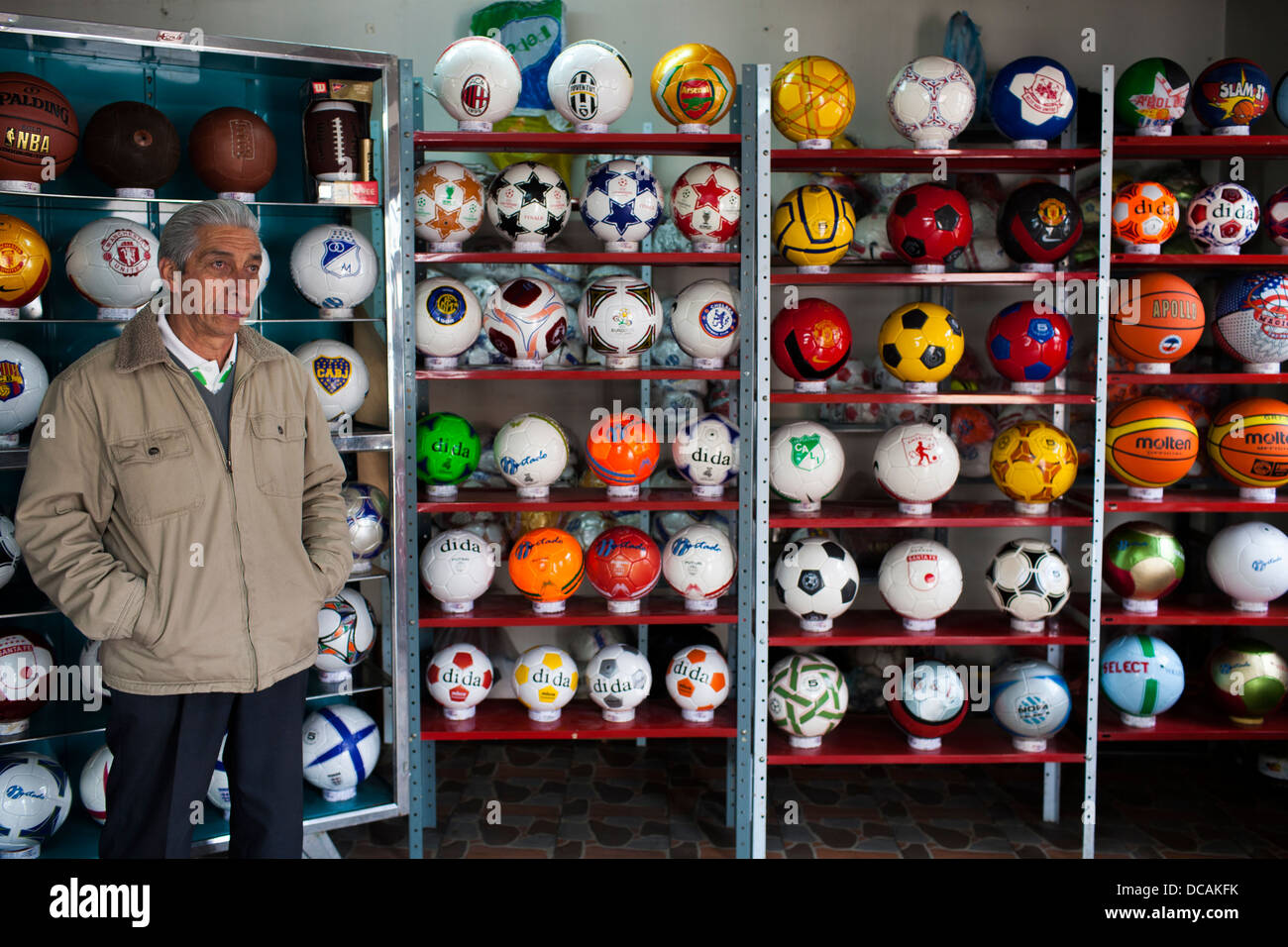 A shop owners poses by his selection of balls for sale in a workshop in Mongui, Boyaca District in Colombia Stock Photo