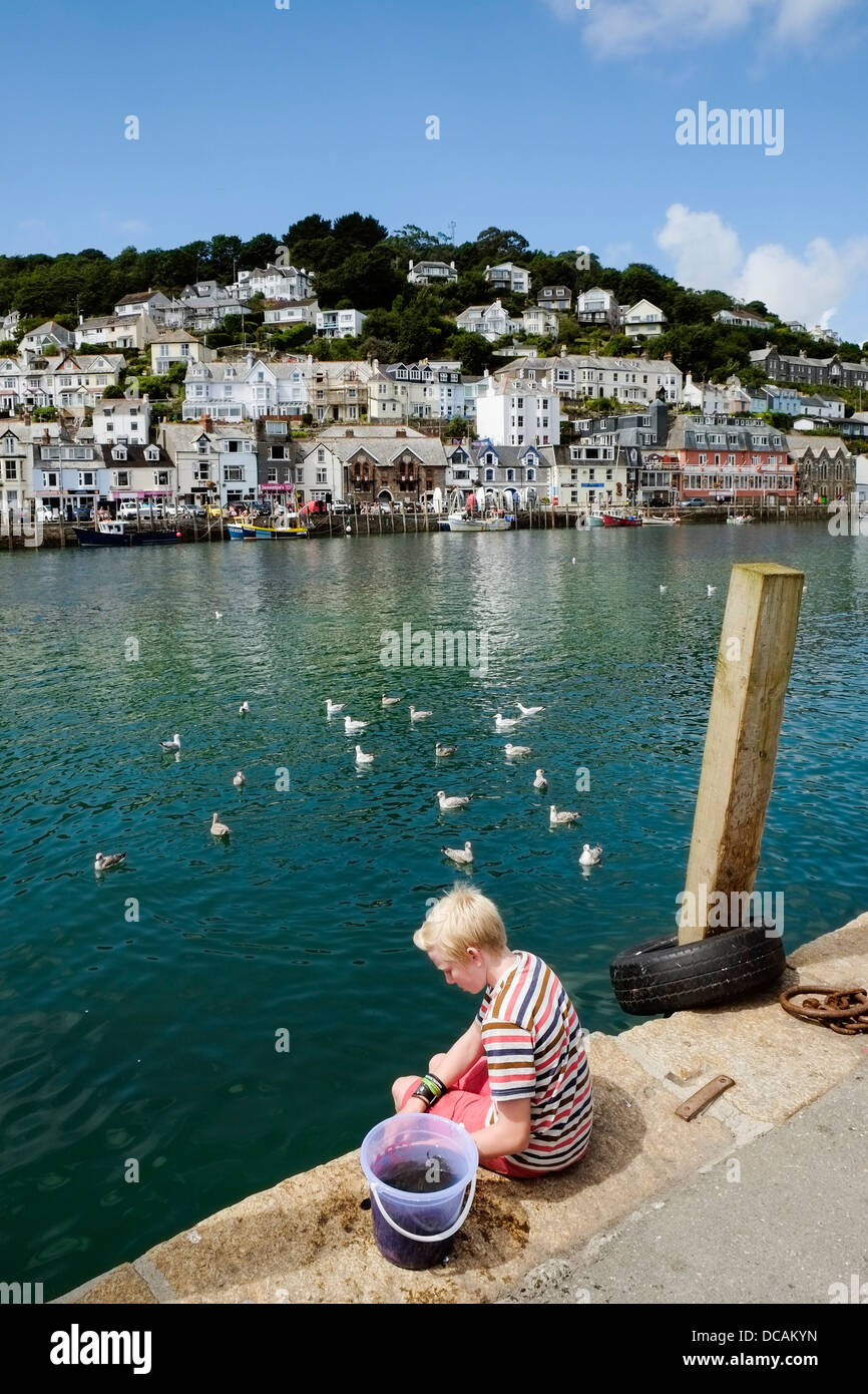 A young boy crabbing from the quay in Looe in Cornwall. Stock Photo