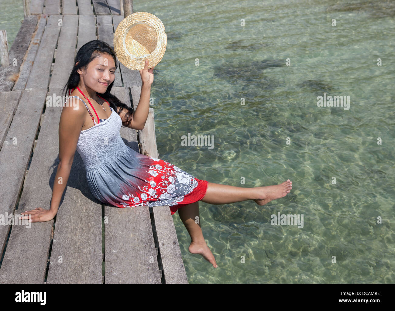 young woman in dress sitting by the sea Stock Photo - Alamy