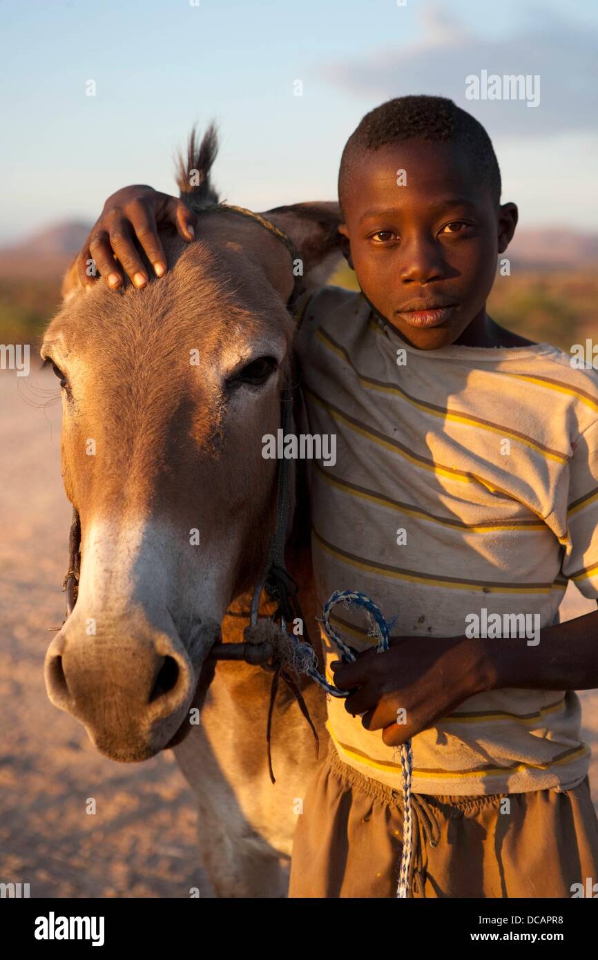 Children with their donkeys are pictured on the street to Palmwag in the Damaraland near Twyvelfontein in Namibia, 8 December 2010. Photo: Tom Schulze Stock Photo