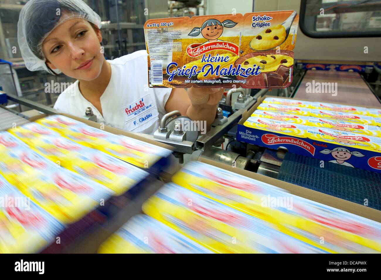 Weißenfels, Germany. 14th Aug, 2013. Employee Franziska Gludau holds the new product called 'small semolina meal' ('kleine Grieß-Mahlzeit') at milk factory frischli in the location Weißenfels, Germany, 14 August 2013. The company presented together with th headquarters in Rehberg four new products with semolina© PETER ENDI /dpa picture alliance/Alamy Live News Stock Photo