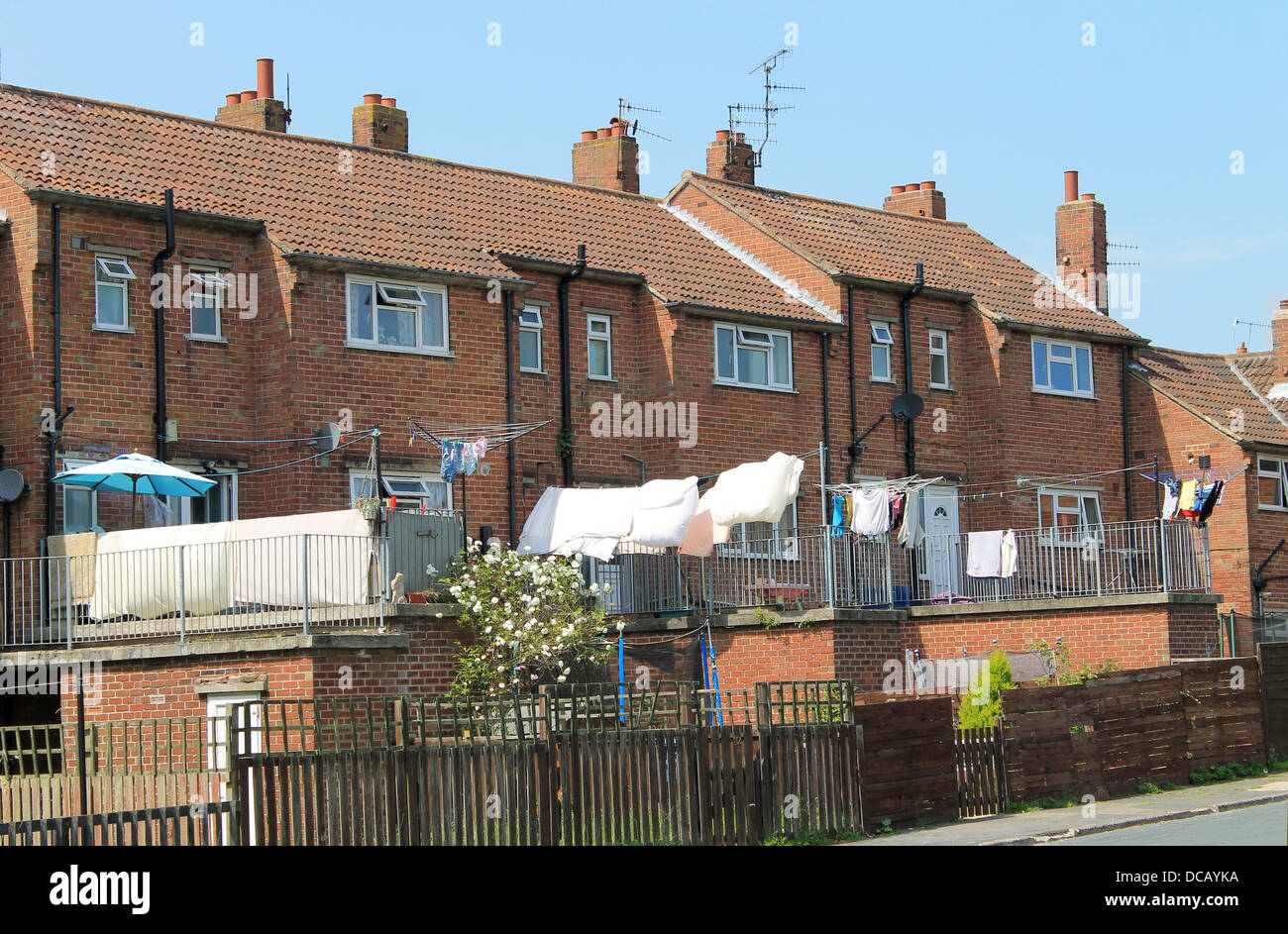 Rear view of modern terrace houses with washing drying in back yard. Stock Photo