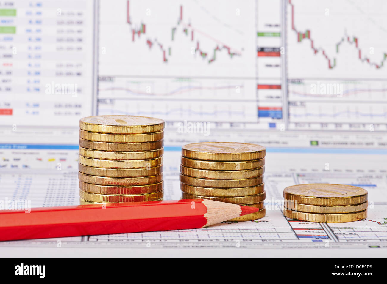 Downtrend coins stacks, red pencil, financial chart as background, red pencil. Selective focus Stock Photo