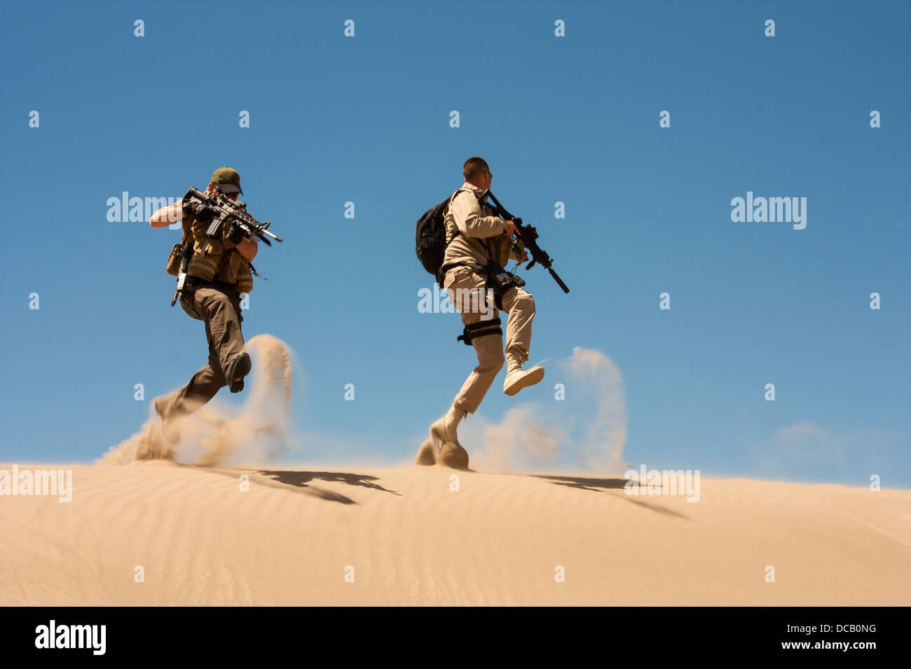 The Special Operations agents in action, jump and cover in the desert sands. Stock Photo