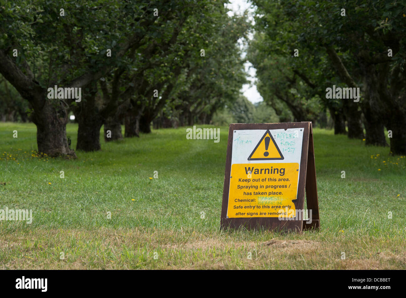 Spraying herbicide warning sign in the apple orchard at RHS Wisley gardens. Surrey, England Stock Photo