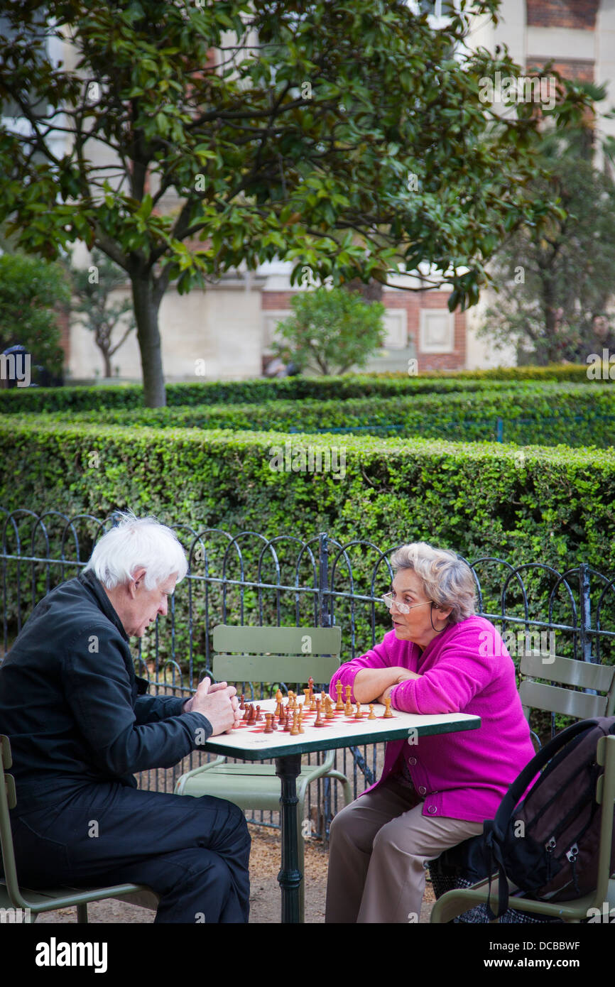 Older couple playing chess in the Jardin du Luxembourg in the Latin Quarter, Paris France Stock Photo