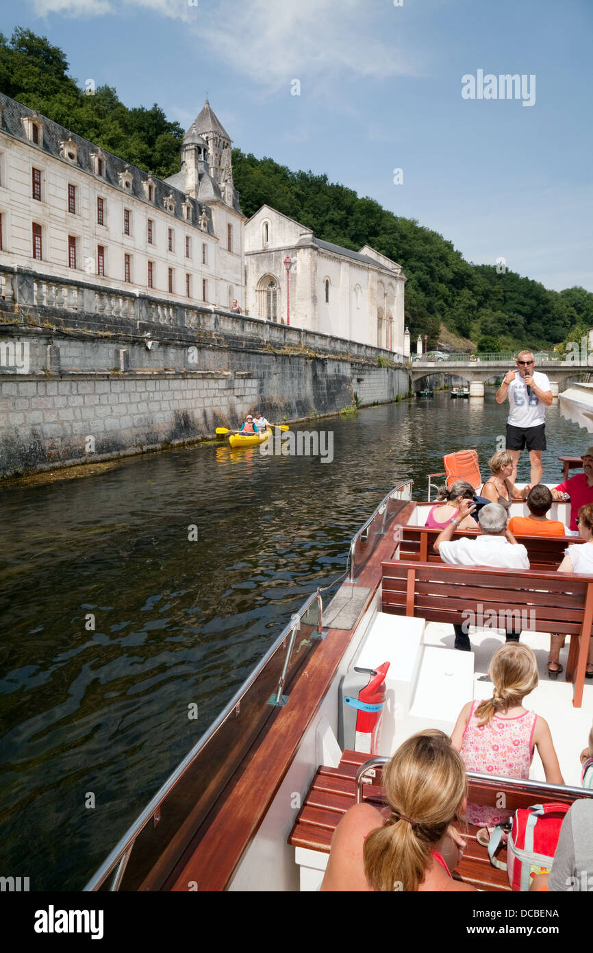Tourists on a guided boat trip on the river Dronne by the Benedictine Abbey, at Brantome, the Dordogne, France Europe Stock Photo