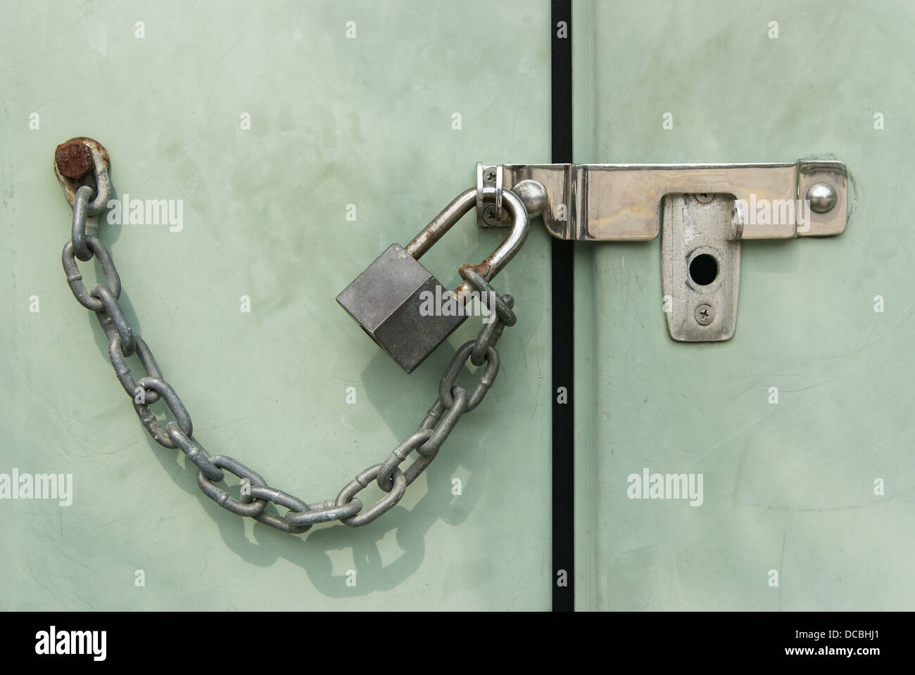Grunge padlock chained and locked on telephone exchange cabinet Stock Photo