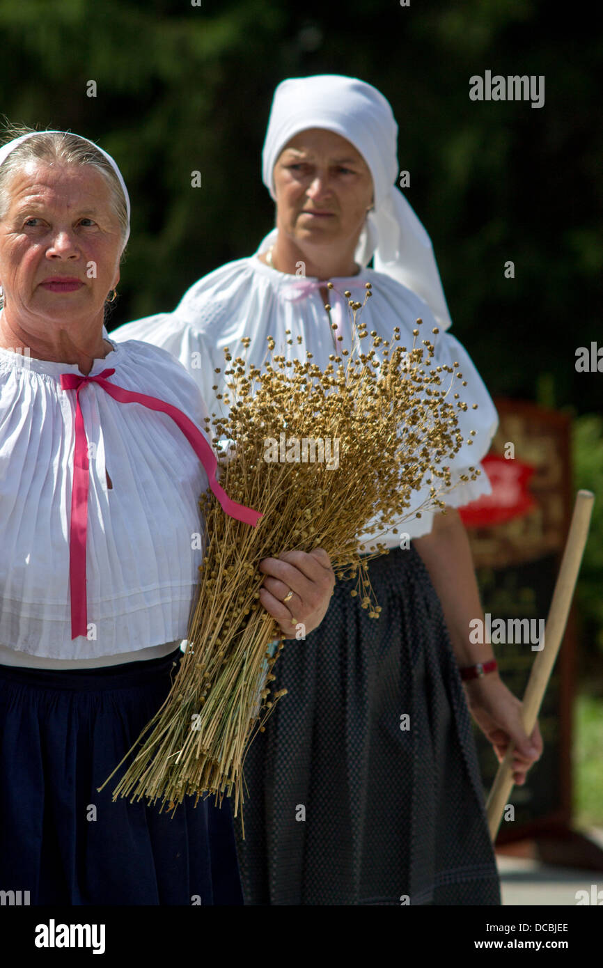 Women in folk costume with holding flax in hands Stock Photo