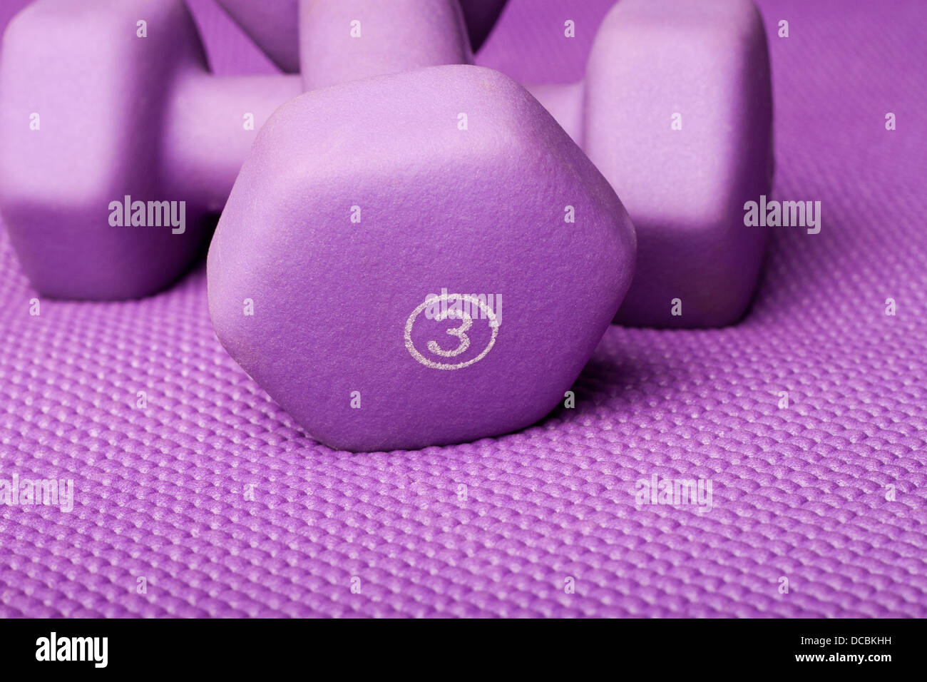 Three pound weight on a purple yoga mat Stock Photo
