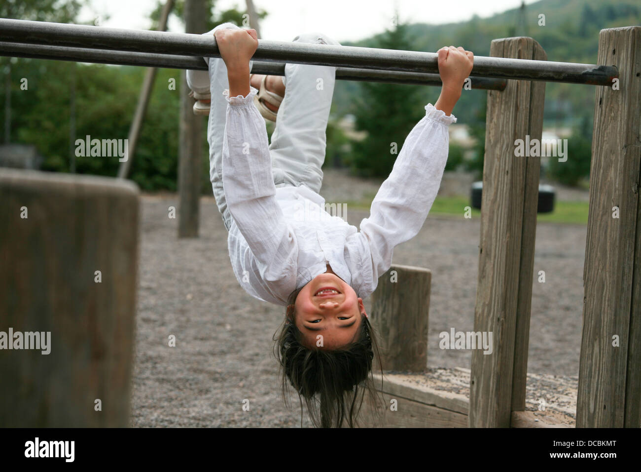 Little girl upside down at playground Stock Photo - Alamy