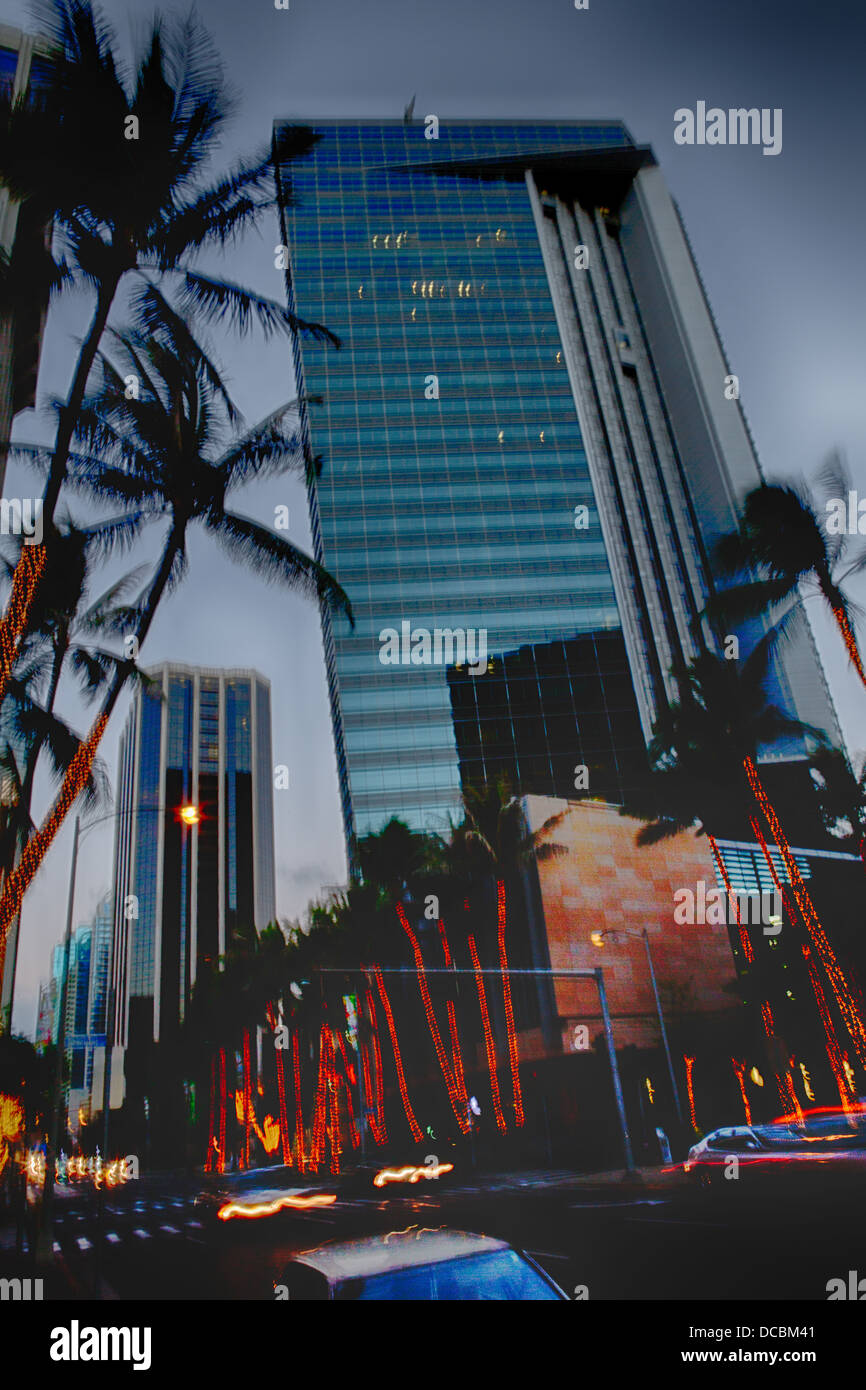 Downtown Honolulu at Bishop Street, dusk HDR, streaming car lights, palm trees and buildings. Stock Photo