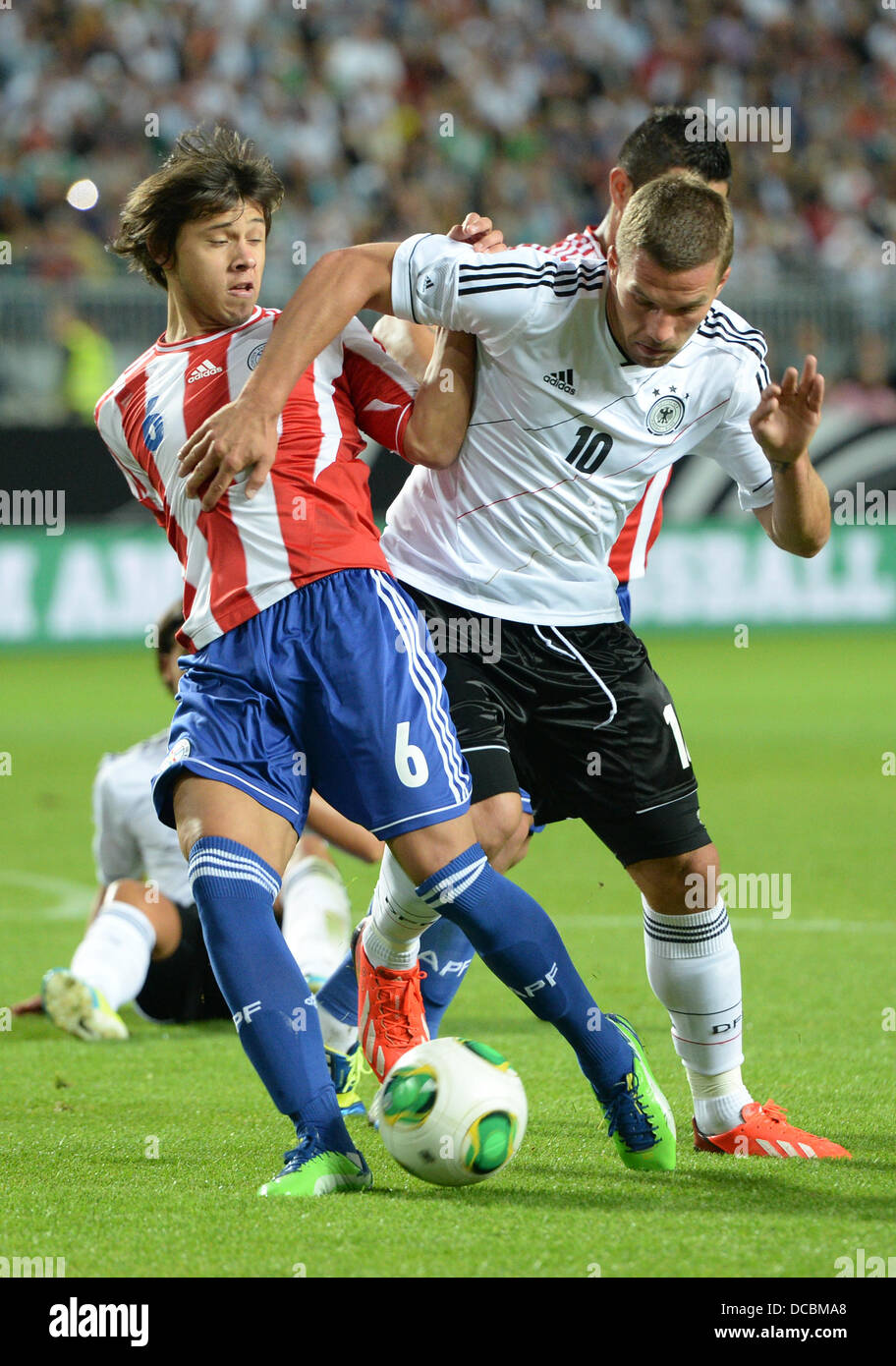Kaiserslautern, Germany. 14th Aug, 2013. Germany's Lukas Podolski (R) and Paraguay's Oscar Romero (l) vie for the ball during the international friendly soccer match between Germany vs Paraguay at Fritz-Walter-Stadium in Kaiserslautern, Germany, 14 August 2013. Photo: Boris Roessler/dpa/Alamy Live News © dpa picture alliance/Alamy Live News Stock Photo