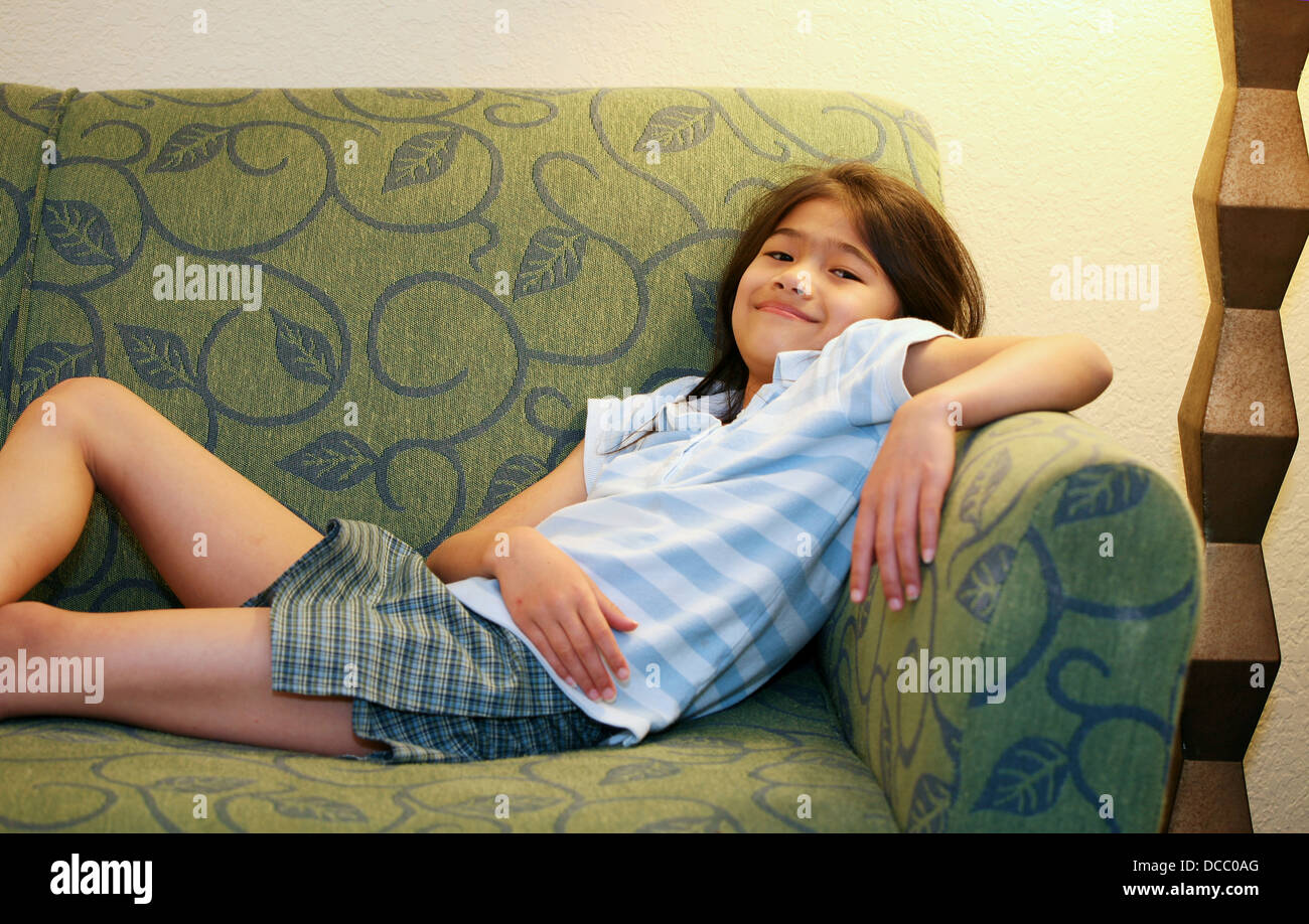 Little girl relaxing on couch Stock Photo