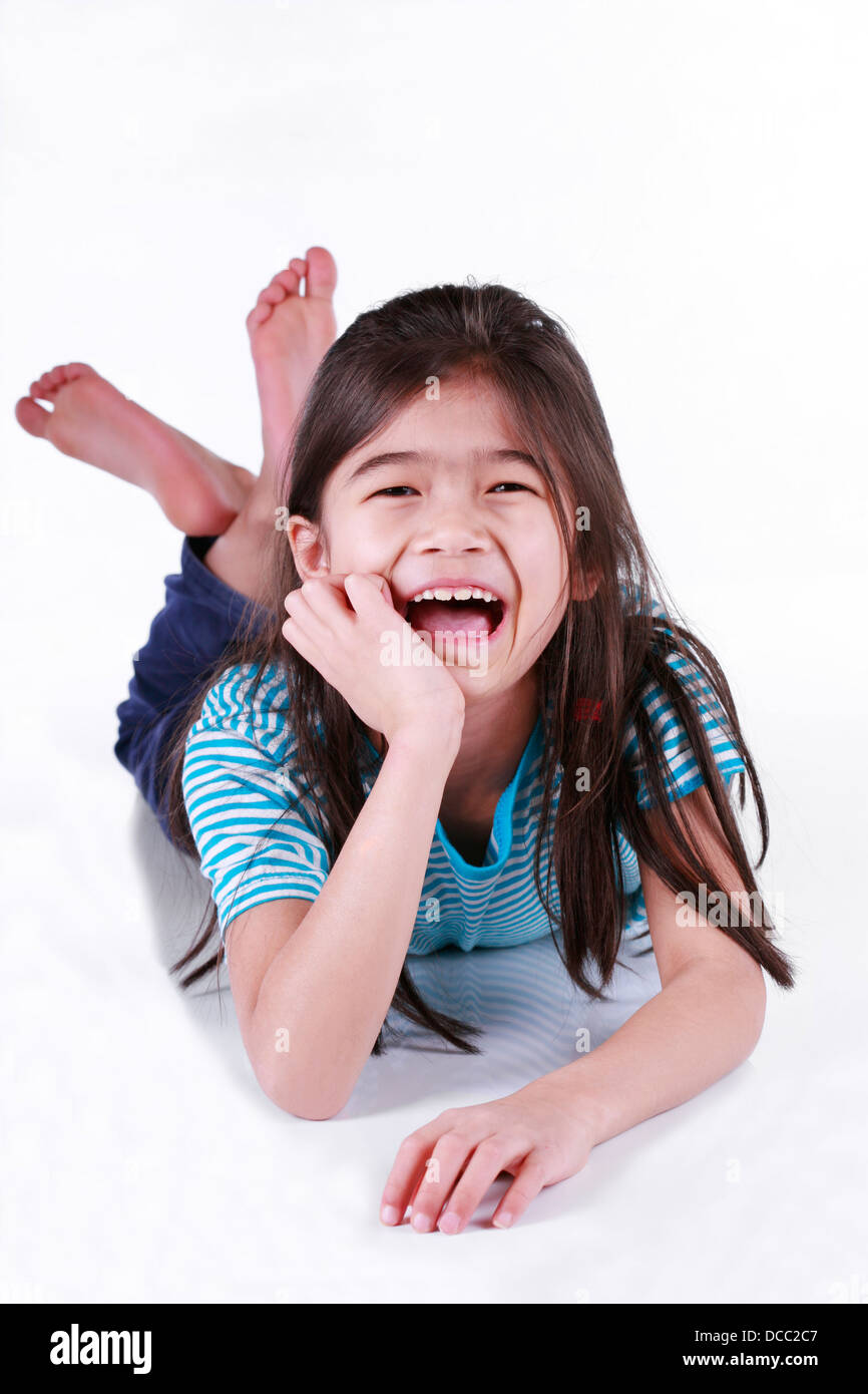 Happy little girl lying on floor Stock Photo - Alamy