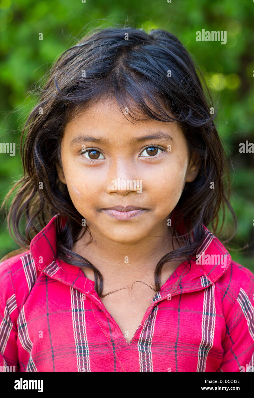 Beautiful young Tharu girl wearing a traditional cotton shirt in the Terai region in Nepal Stock Photo