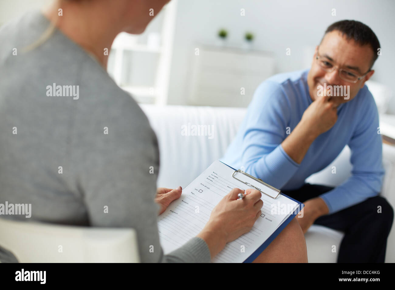 Female psychologist consulting mature man during psychological therapy