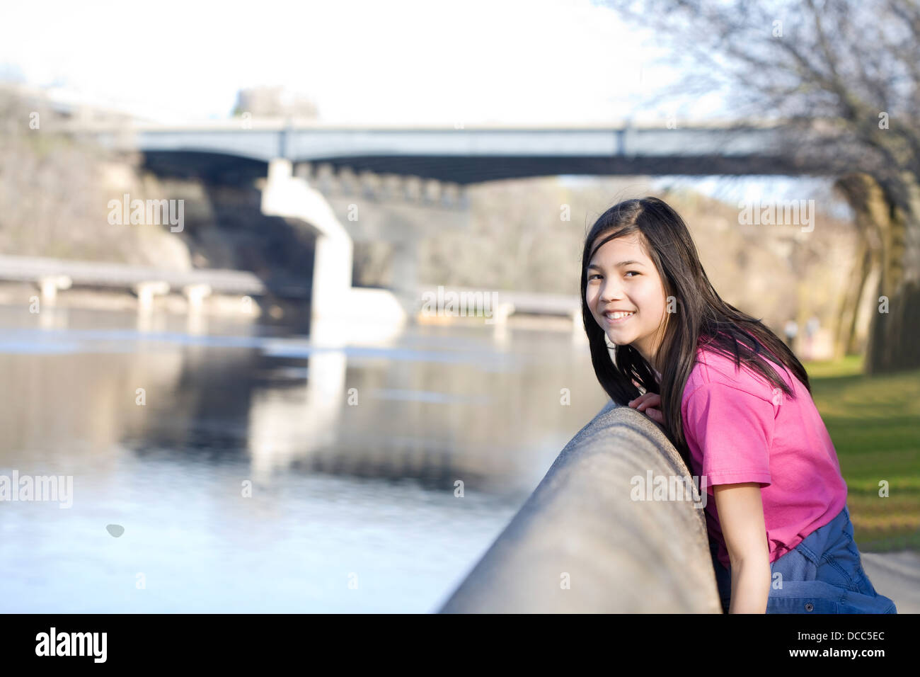 Girl standing on river bank Stock Photo - Alamy